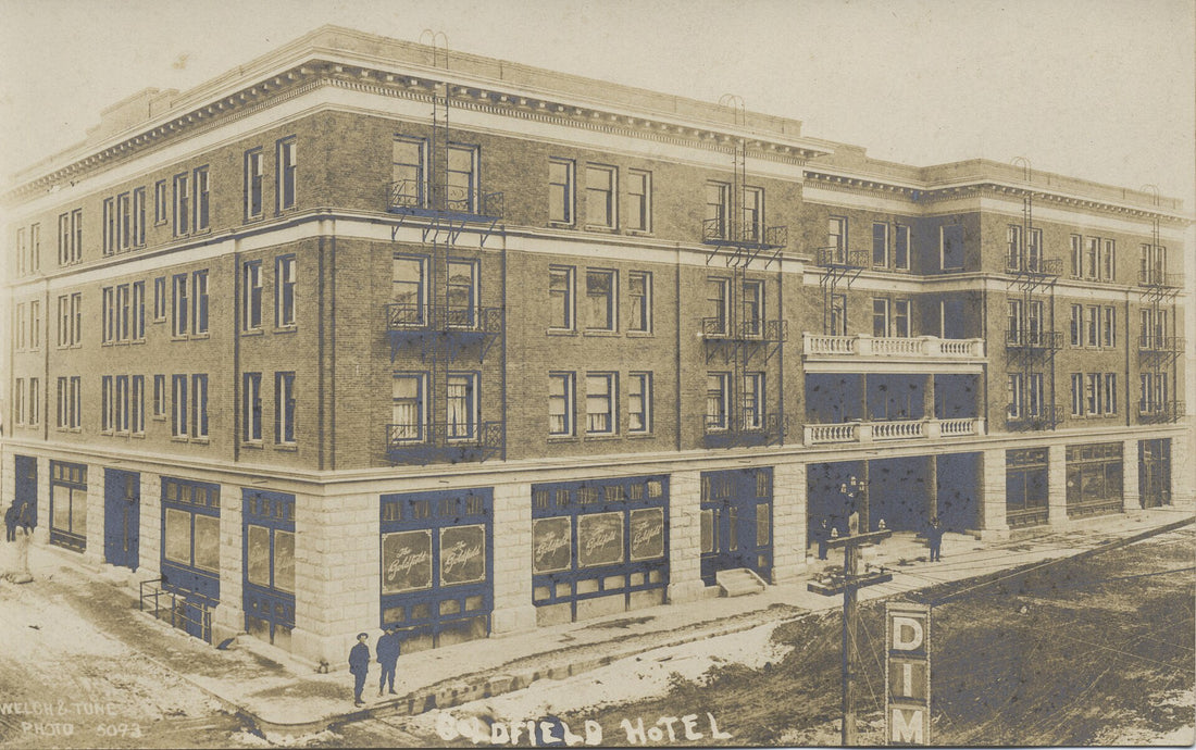 The Goldfield Hotel in Goldfield, Nevada, on an early twentieth-century real-photo postcard, showing the four-story stone and brick hotel at the height of the gold boom. Miami University Libraries postcard collection, no known copyright restrictions.