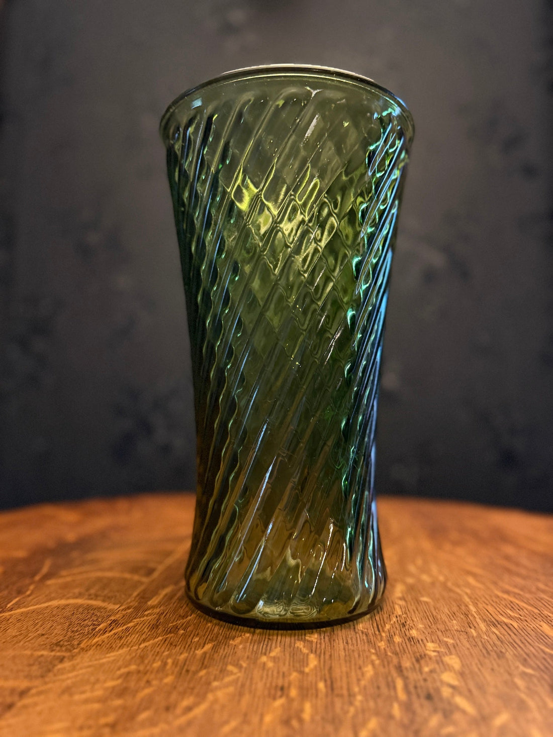A mid-century emerald green spiral optic glass vase, circa 1950-1965, from the Viridian Eclection collection. A period-appropriate piece, not the Holiday Hotel itself.