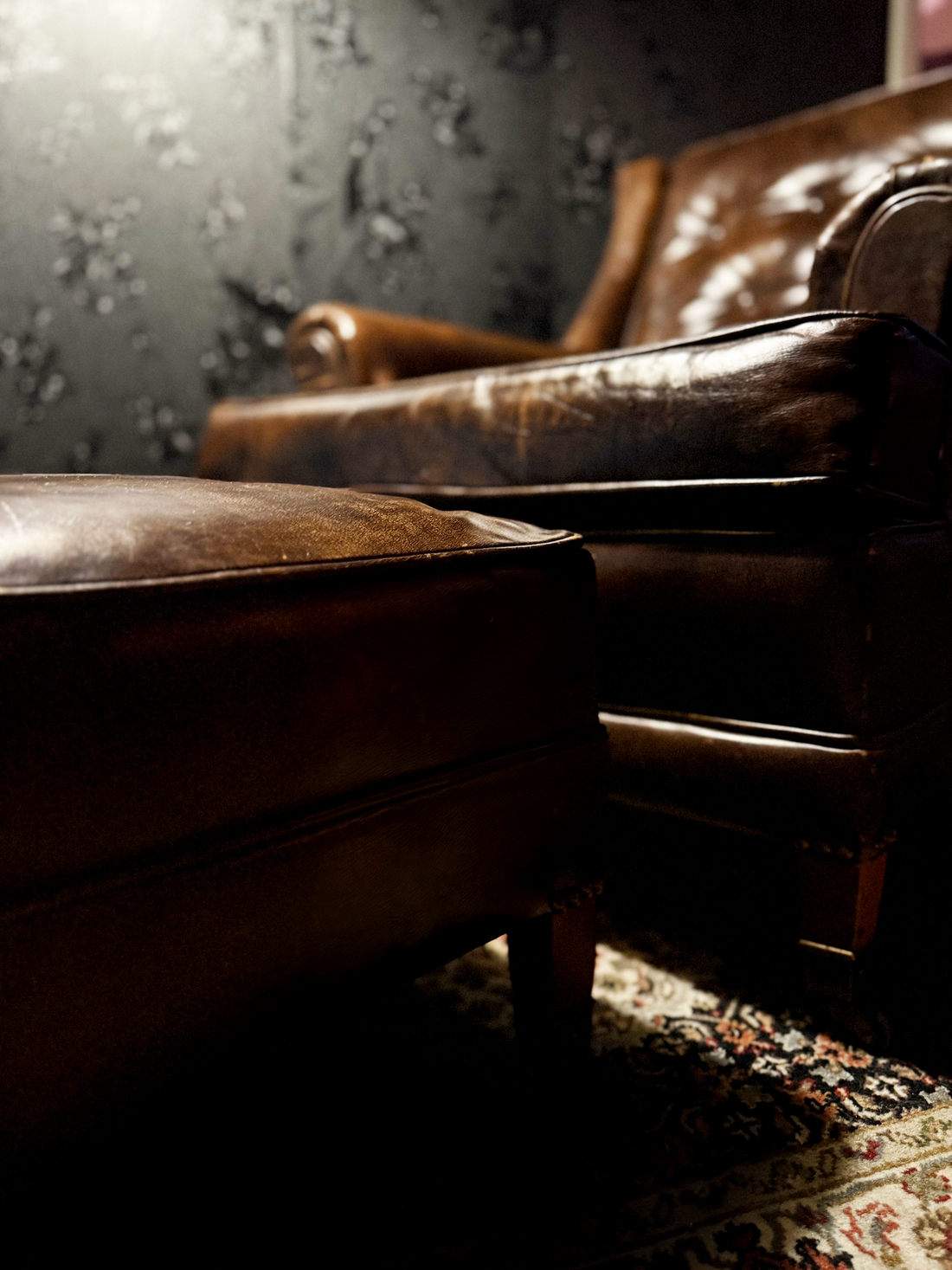 A vintage leather club chair and ottoman, c. 1930s, from the Viridian Eclection collection. A period-appropriate piece, not the Old Post Office itself.