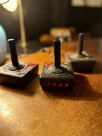 Set of Three Original Atari CX40 Joysticks with Framed Montgomery Ward Catalog Page, c. 1980s | Curated Reductions