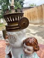Miniature Figural Oil Lamp, Porcelain Courting Couple Flanking a Gilt Fluted Font, with Original Brass Burner, Continental, c. 1890–1940