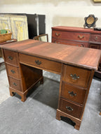 Colonial Revival Kneehole Desk, Seven Drawers with Batwing Brasses and Bracket Feet, Refinished by Walter Hinchman in Sedona Red, Antique Walnut and Mahogany, c. 1940–1955