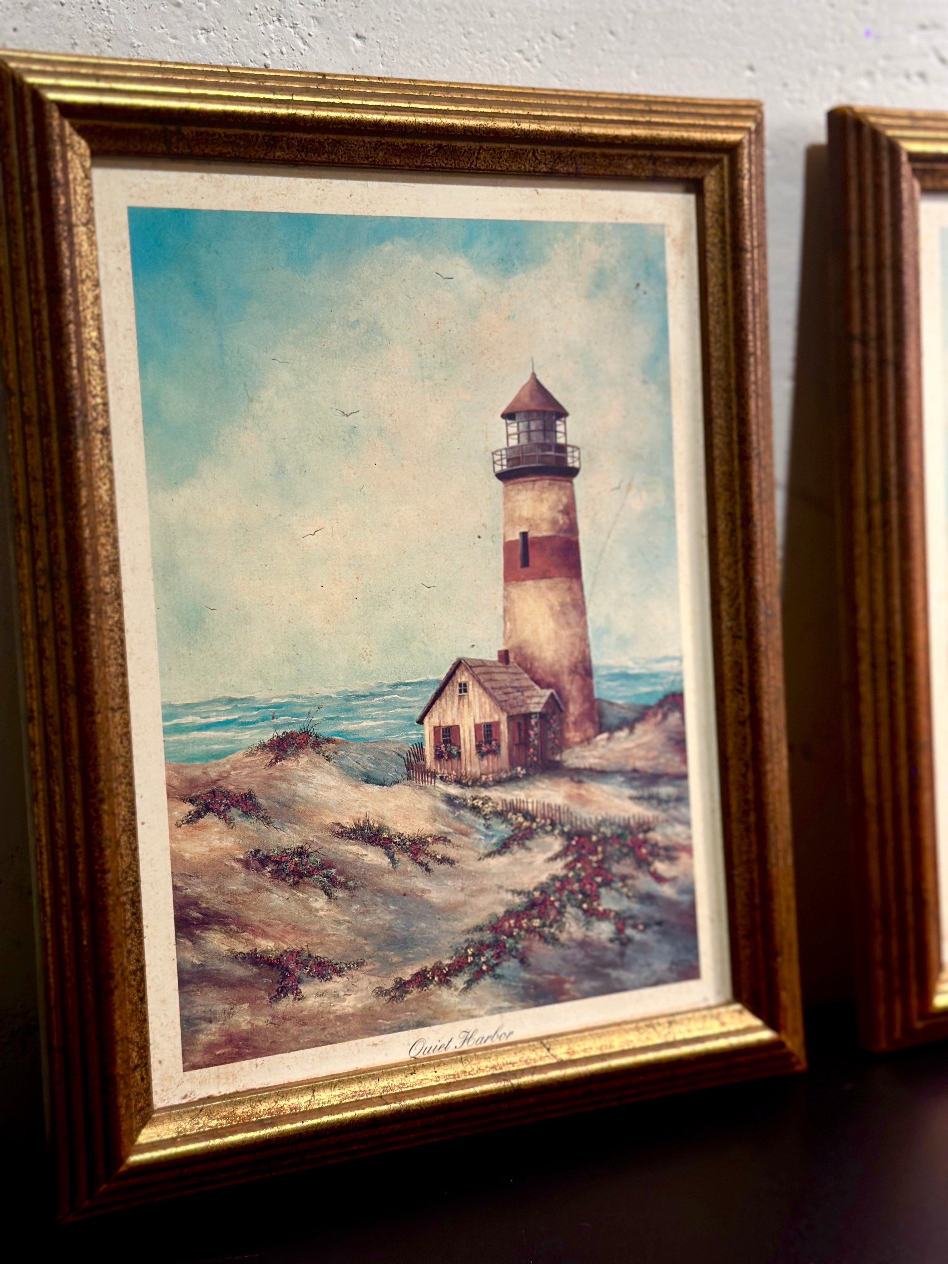 Quiet Harbor & Sandy Pointe Pair of vintage framed lighthouse prints titled Quiet Harbor and Sandy Pointe. Matching coastal artwork set with gilt wood frames, sold together.| Vintage Framed Lighthouse Print Set
