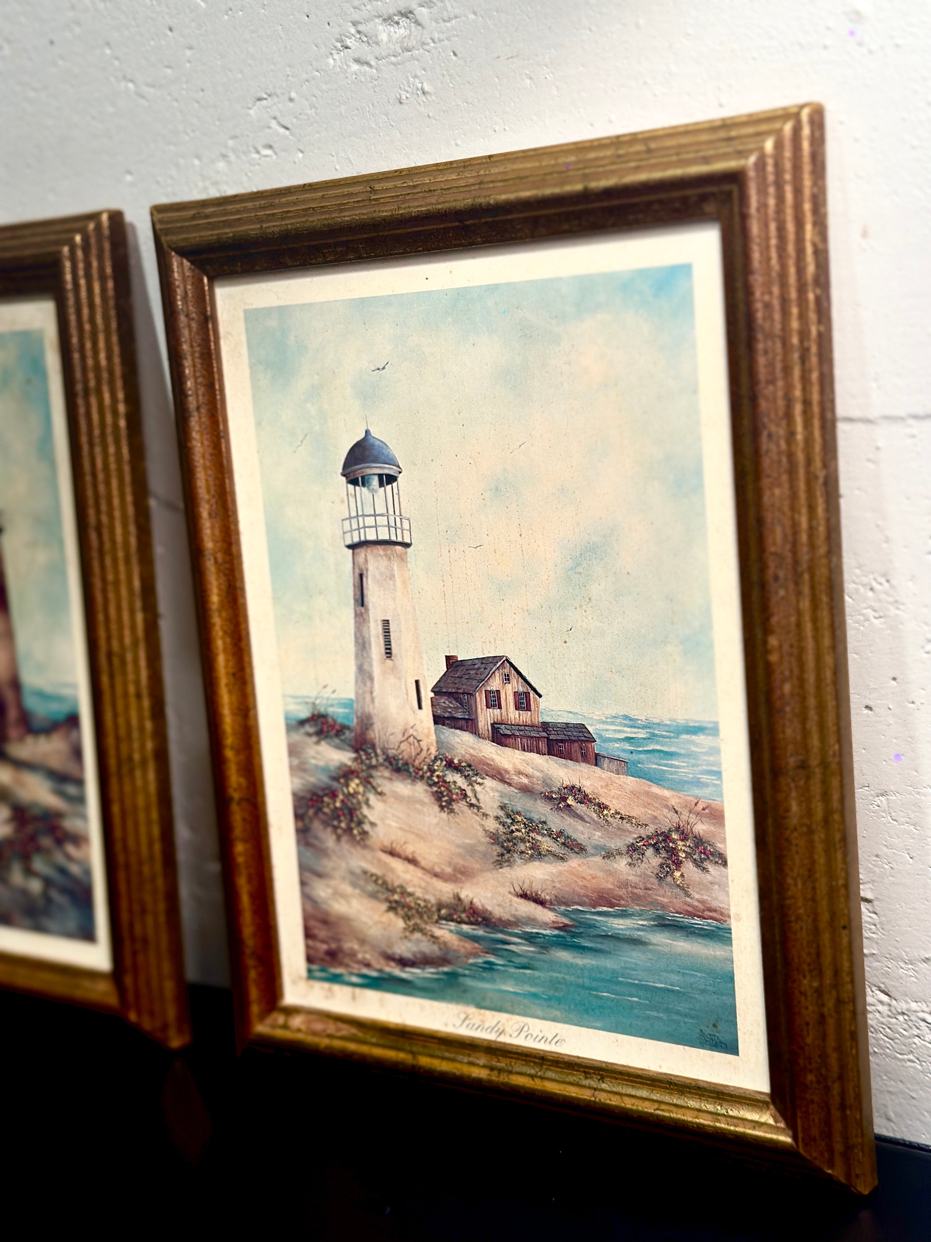 Quiet Harbor & Sandy Pointe Pair of vintage framed lighthouse prints titled Quiet Harbor and Sandy Pointe. Matching coastal artwork set with gilt wood frames, sold together.| Vintage Framed Lighthouse Print Set