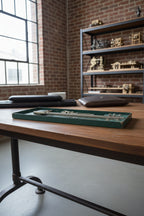 Set of drafting tools in a green case on a wooden surface