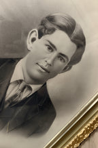 Vintage black and white portrait of a man with a gold frame