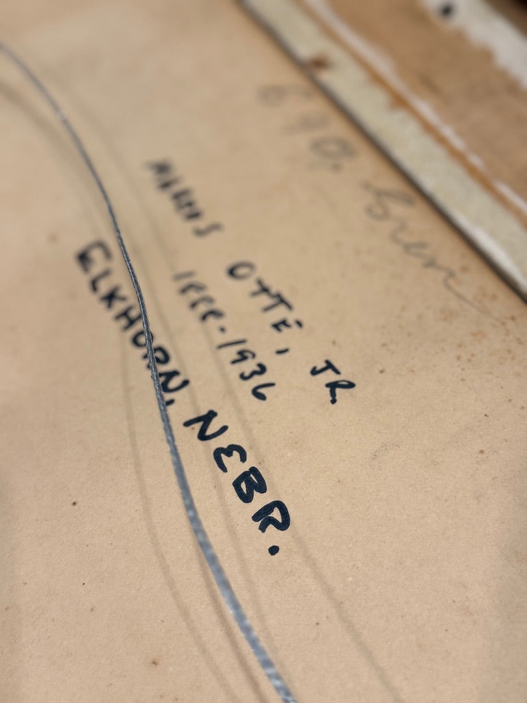 Close-up of a handwritten address on cardboard with 'ELKHORN, NEBR.'