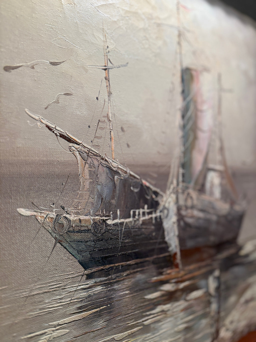 Close-up of a shipwreck with masts and rigging on a textured surface